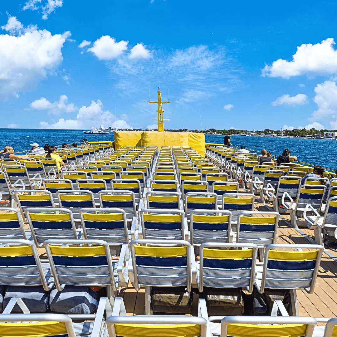 Passengers enjoying the scenery on the Cozumel ferry. Ferry top deck, passengers viewing scenery to Cozumel.