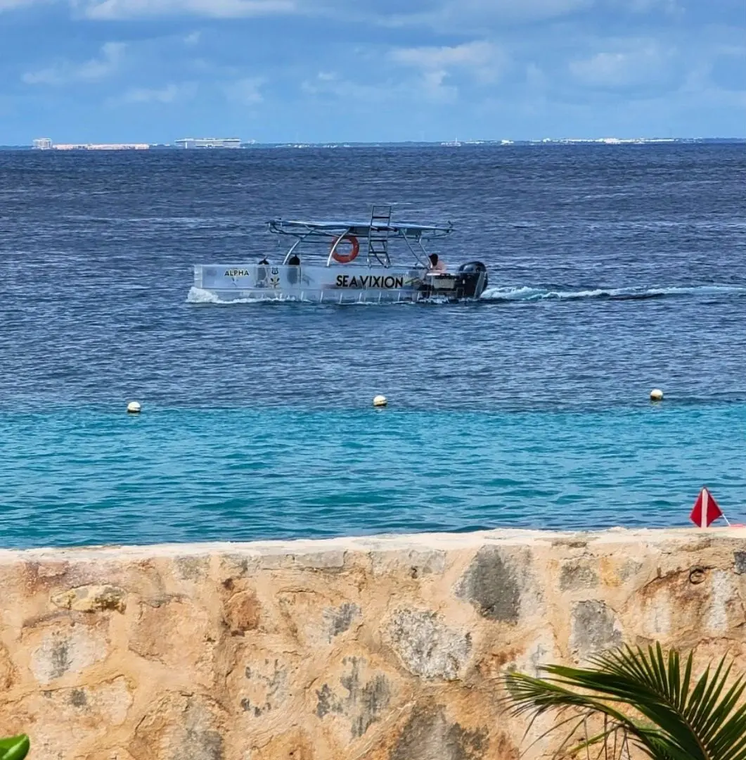 Clear boat tour from Cozumel cruise port with transparent hull and shaded top.