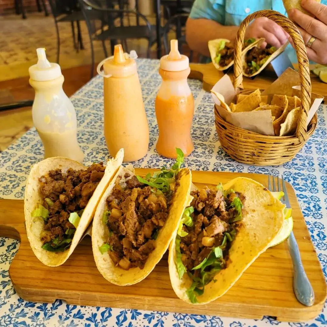 Well-set table of Cozumel-style steak tacos with house sauces and chips.